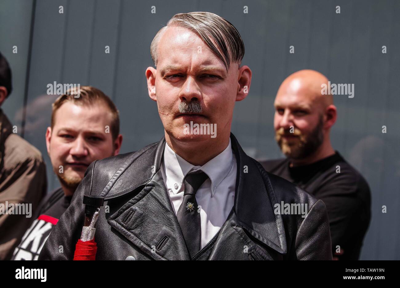 Dortmund, Nordrhein Westfalen, Germany. 25th May, 2019. A neonazi from The Netherlands has fashioned himself into the appearance of Adolph Hitler. On his tie is a pin of the Edelweiss flower, which was used by the SS and is still in use by the Gebirgsjaeger today. Prior to the European Elections, the neonazi party Die Rechte (The Right) organized a rally in the German city of Dortmund to promote their candidate, the incarcerated Holocaust denier Ursula Haverbeck. The demonstration and march were organized by prominent local political figure and neonazi activist Michael Brueck (Michael BrÃ¼ck Stock Photo