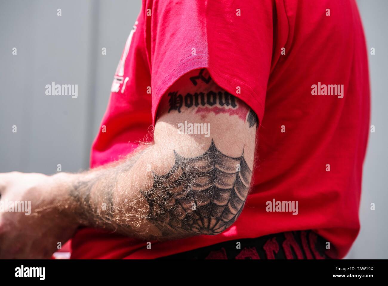 Dortmund, Nordrhein Westfalen, Germany. 25th May, 2019. A neonazi at an event in Dortmund displays a portion of a ''Blood and Honour'' tattoo, denoting membership to this banned terror group, as well as a 777 Triskele above it. Prior to the European Elections, the neonazi party Die Rechte (The Right) organized a rally in the German city of Dortmund to promote their candidate, the incarcerated Holocaust denier Ursula Haverbeck. The demonstration and march were organized by prominent local political figure and neonazi activist Michael Brueck (Michael BrÃ¼ck) who enlisted the help of not only G Stock Photo