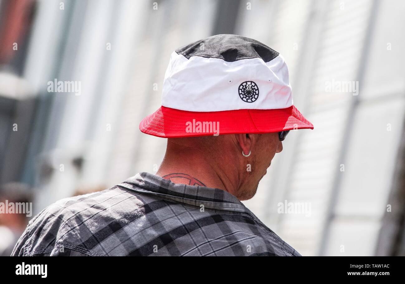 Dortmund, Nordrhein Westfalen, Germany. 25th May, 2019. A neonazi in Dortmund, Germany wears a hat with the colors of Germany's 1933-35 flag with a Black Sun nazi esoteric embroidery. Prior to the European Elections, the neonazi party Die Rechte (The Right) organized a rally in the German city of Dortmund to promote their candidate, the incarcerated Holocaust denier Ursula Haverbeck. The demonstration and march were organized by prominent local political figure and neonazi activist Michael Brueck (Michael BrÃ¼ck) who enlisted the help of not only German neonazis, but also assistance from Rus Stock Photo