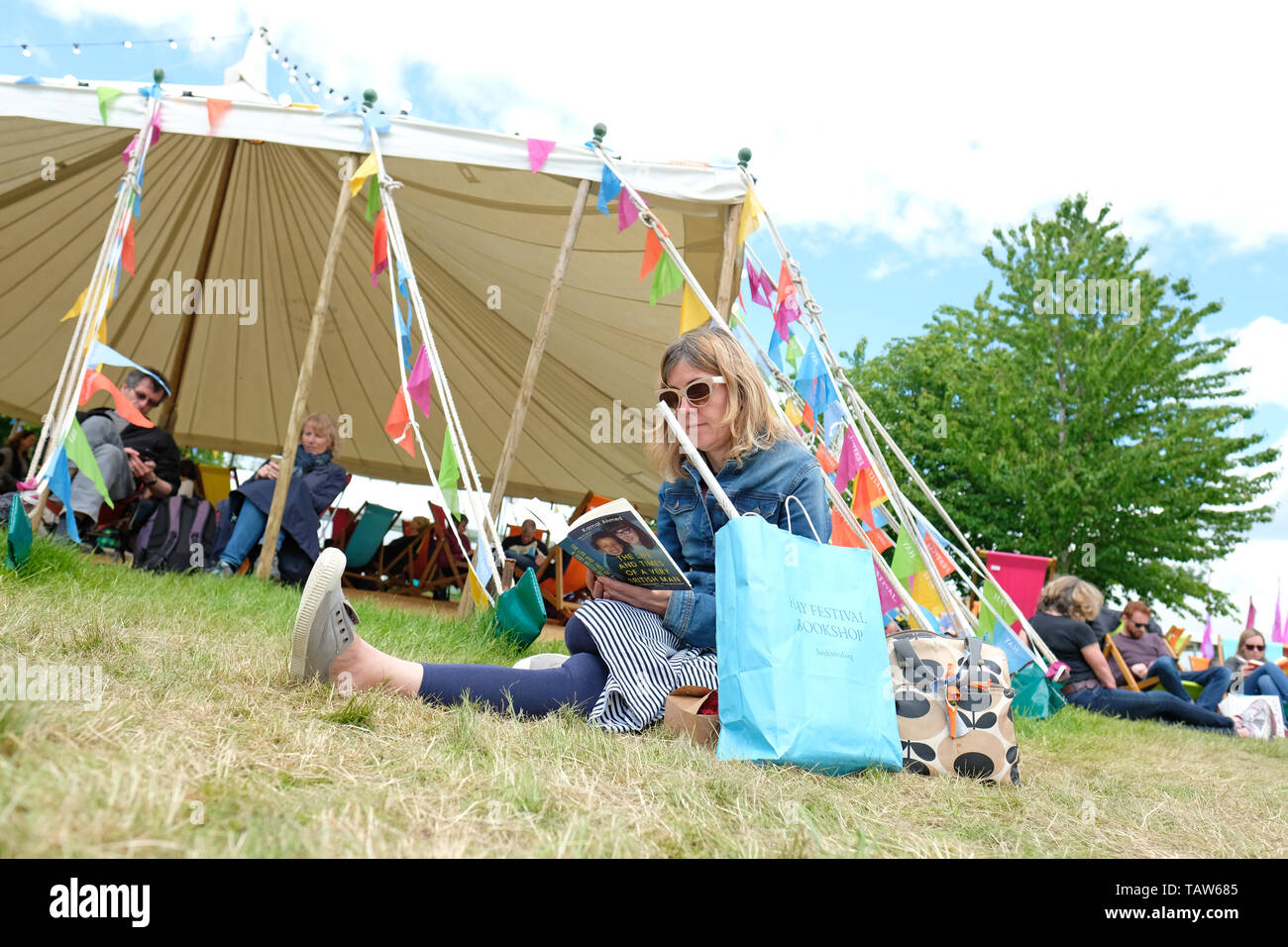 Hay Festival, Hay on Wye, Powys, Wales, UK - Tuesday 28th May 2019 - A  visitor enjoys a break on the Festival lawns between events and speakers at  the Hay Festival. Photo