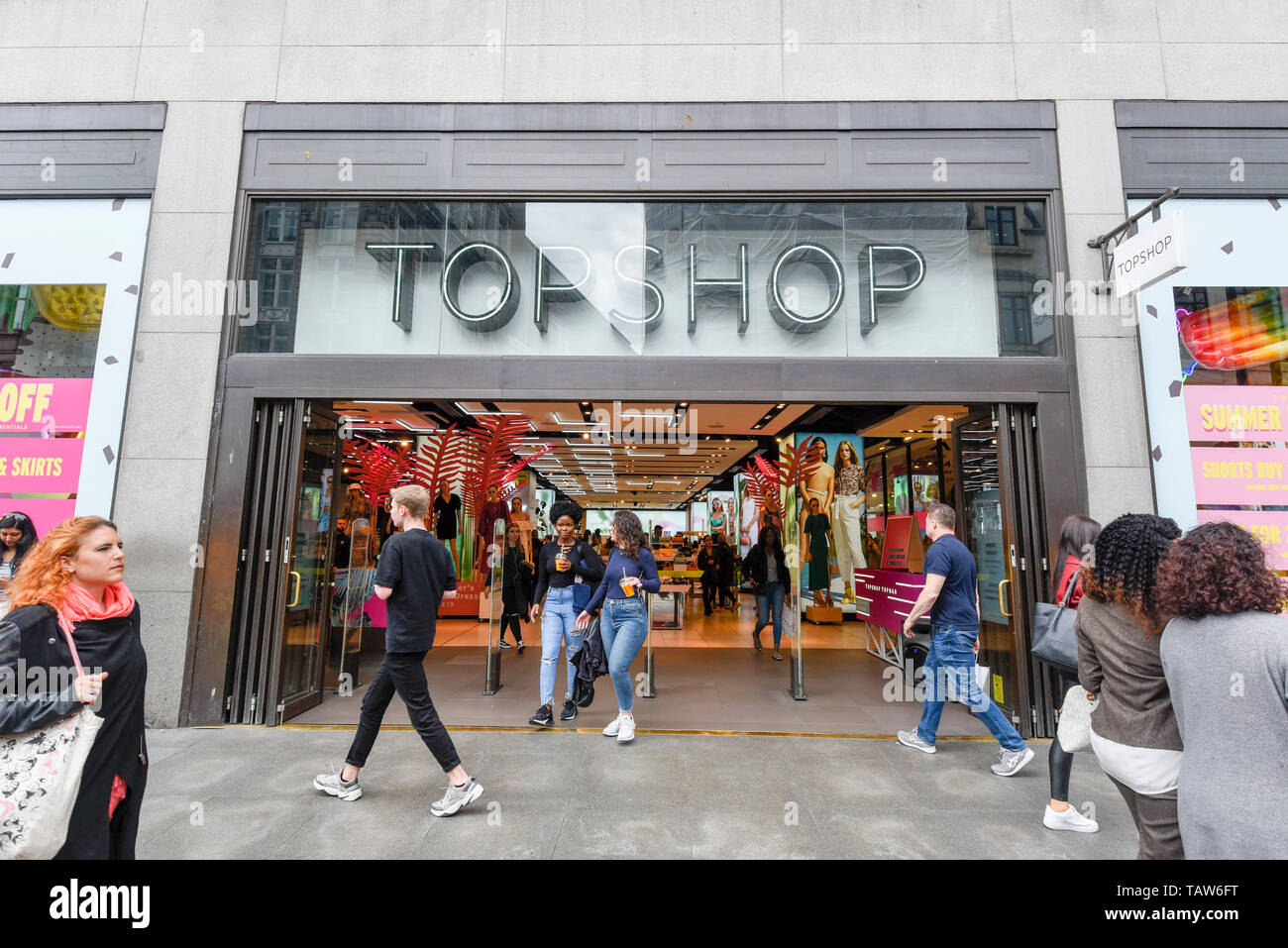 London, UK. 28 May 2019. Shoppers pass by outside the Topshop store on  Oxford Circus. Sir Philip Green's Arcadia Group is to close the adjacent  flagship Miss Selfridge store in July 2019