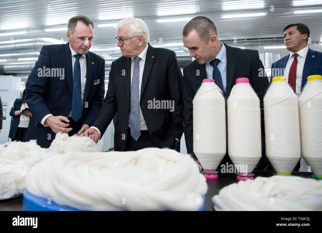 Taschkent, Uzbekistan. 28th May, 2019. Federal President Frank-Walter Steinmeier (M) visits the Bakan Tex yarn spinning mill and is guided through the production facilities by Witali Schulz (l), Regional Manager of Trützschler Textilmaschinenfabrik, and General Director Botir Muchitdinow (r). President Steinmeier and his wife are on a two-day state visit to Uzbekistan. They are accompanied by numerous business representatives and cultural workers. Credit: Bernd von Jutrczenka/dpa/Alamy Live News Stock Photo