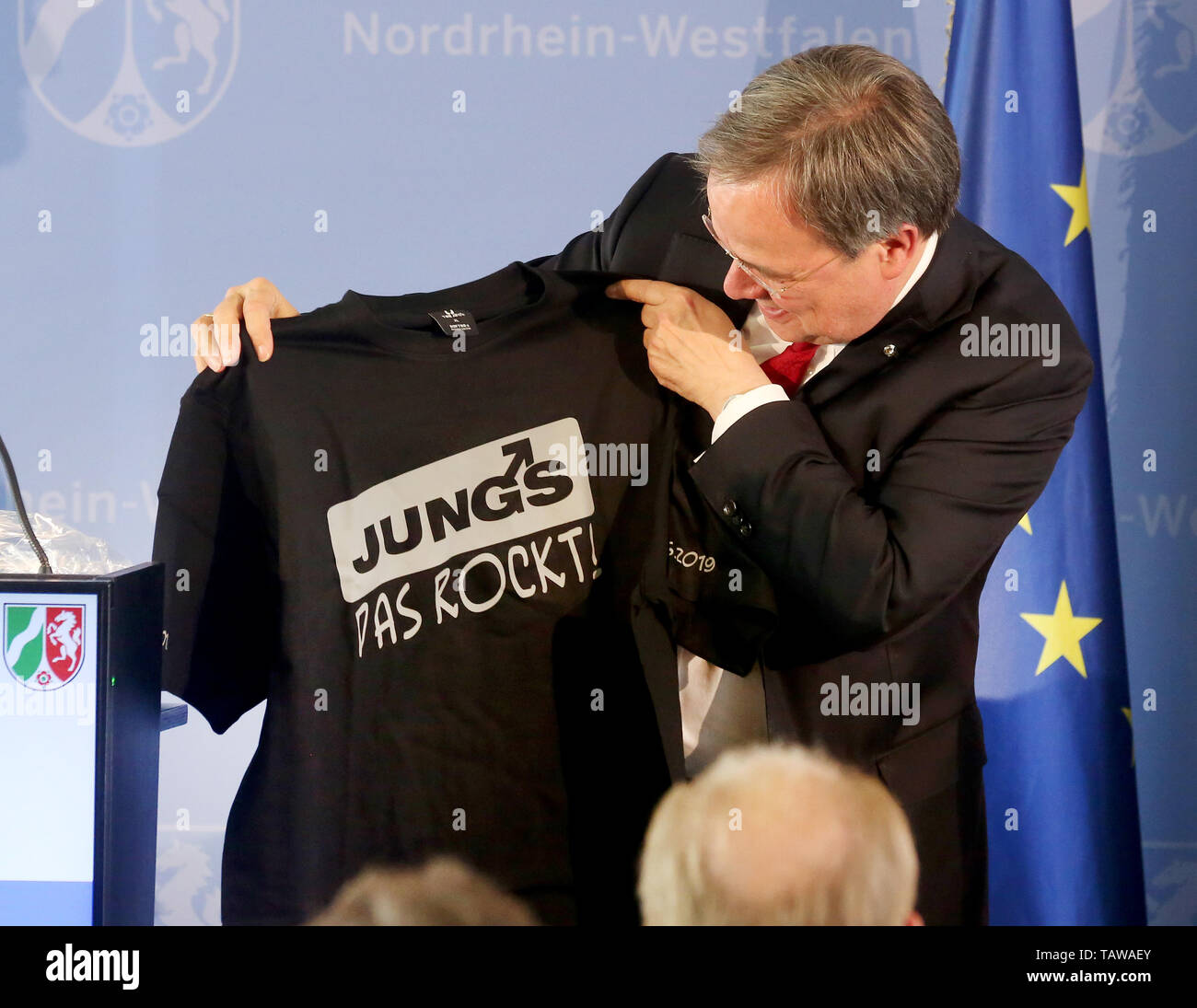 Duesseldorf, Germany. 28th May, 2019. Armin Laschet (CDU), Prime Minister of North Rhine-Westphalia, received a T-shirt as a present from the prizewinners, the Duisburg 'Jungs e.V.', at the Mevlüde Genc Medal ceremony. The state government had donated the Mevlüde-Genç Medal for special services to tolerance, reconciliation between cultures and the peaceful coexistence of religions. The Genç family was victims of the Solingen arson attack on the night of 29 May 1993. (headline correction) Credit: Roland Weihrauch/dpa/Alamy Live News Stock Photo