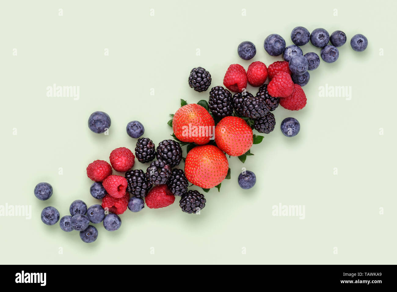 Fresh Summer Berries on plain green background Stock Photo