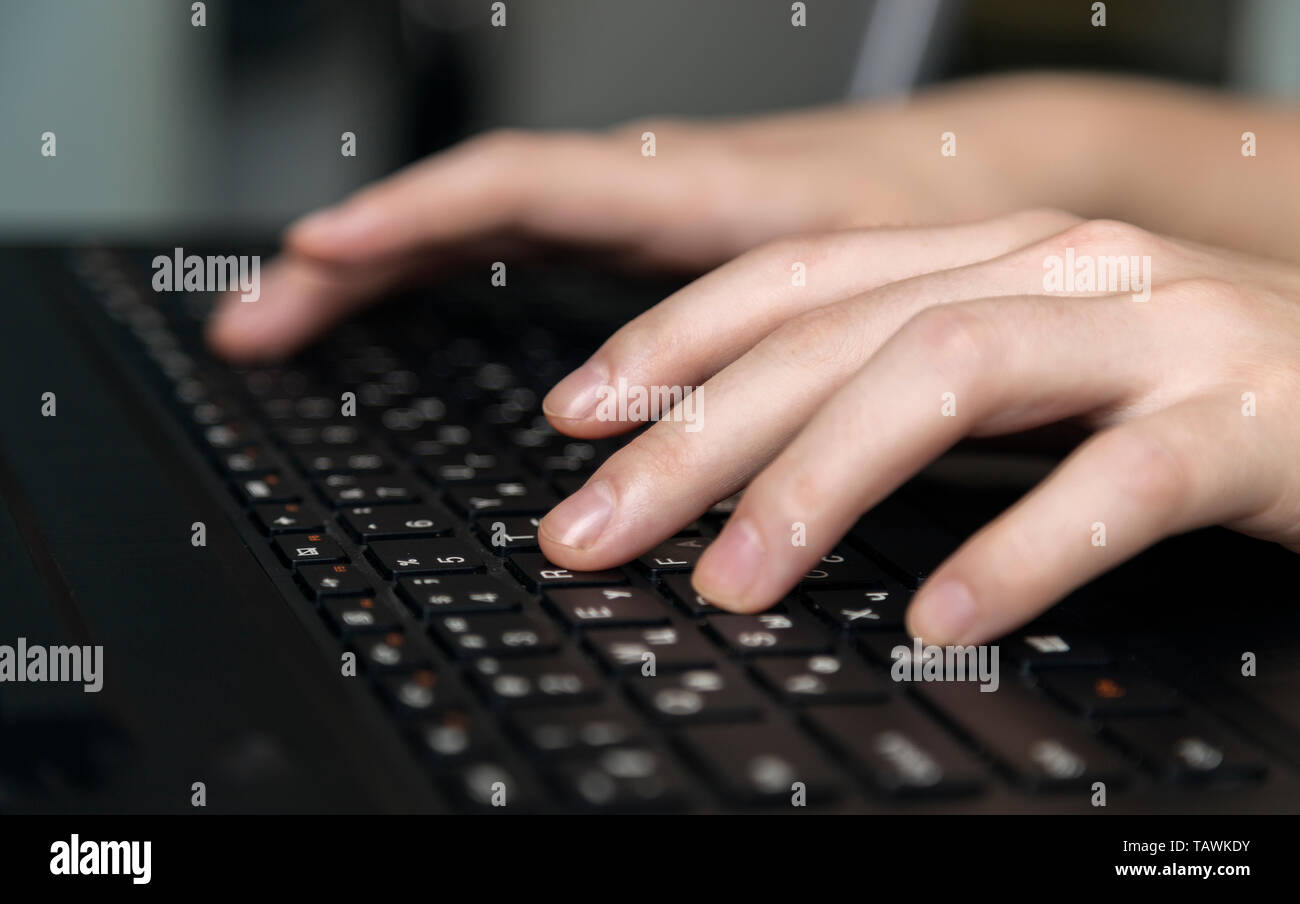 Hands typing on black keyboard, close up Stock Photo