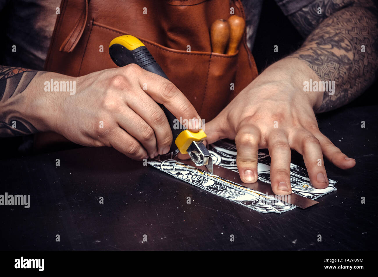 Worker of leather works with leatherwork in a workshop. Stock Photo