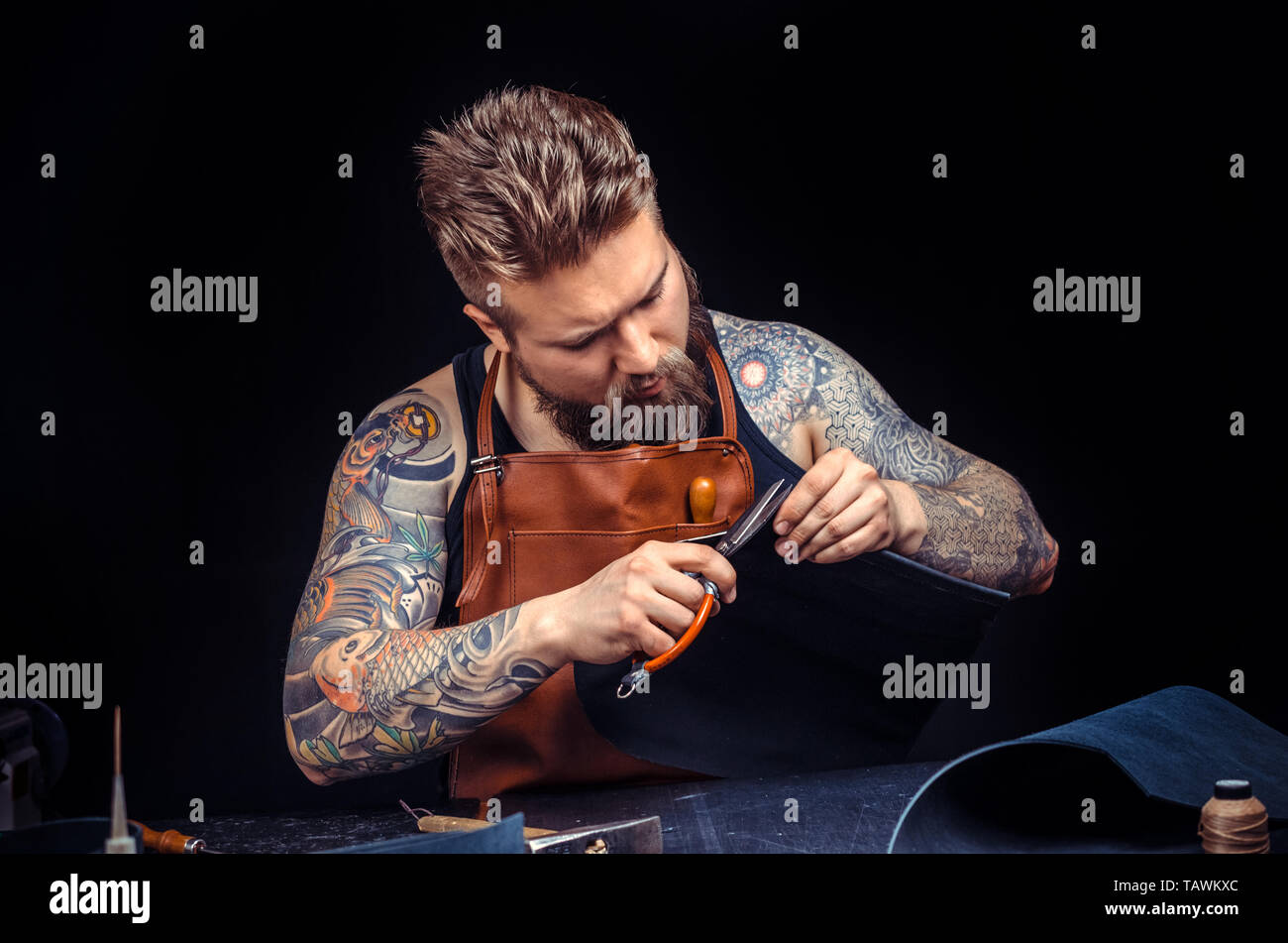 Handicraftsman wording with leather goods at the studio. Stock Photo