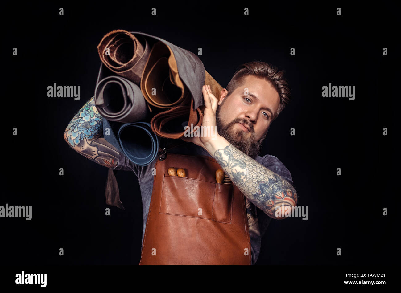 Craftsman working with leather creates a new leatherwork in the studio. Stock Photo