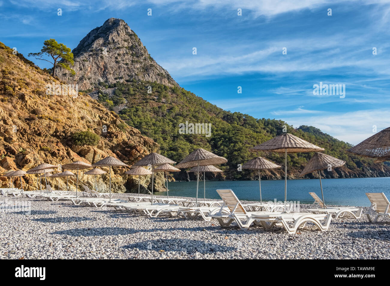 Beach umbrellas and sunbeds on the Adrasan beach in Turkey Stock Photo