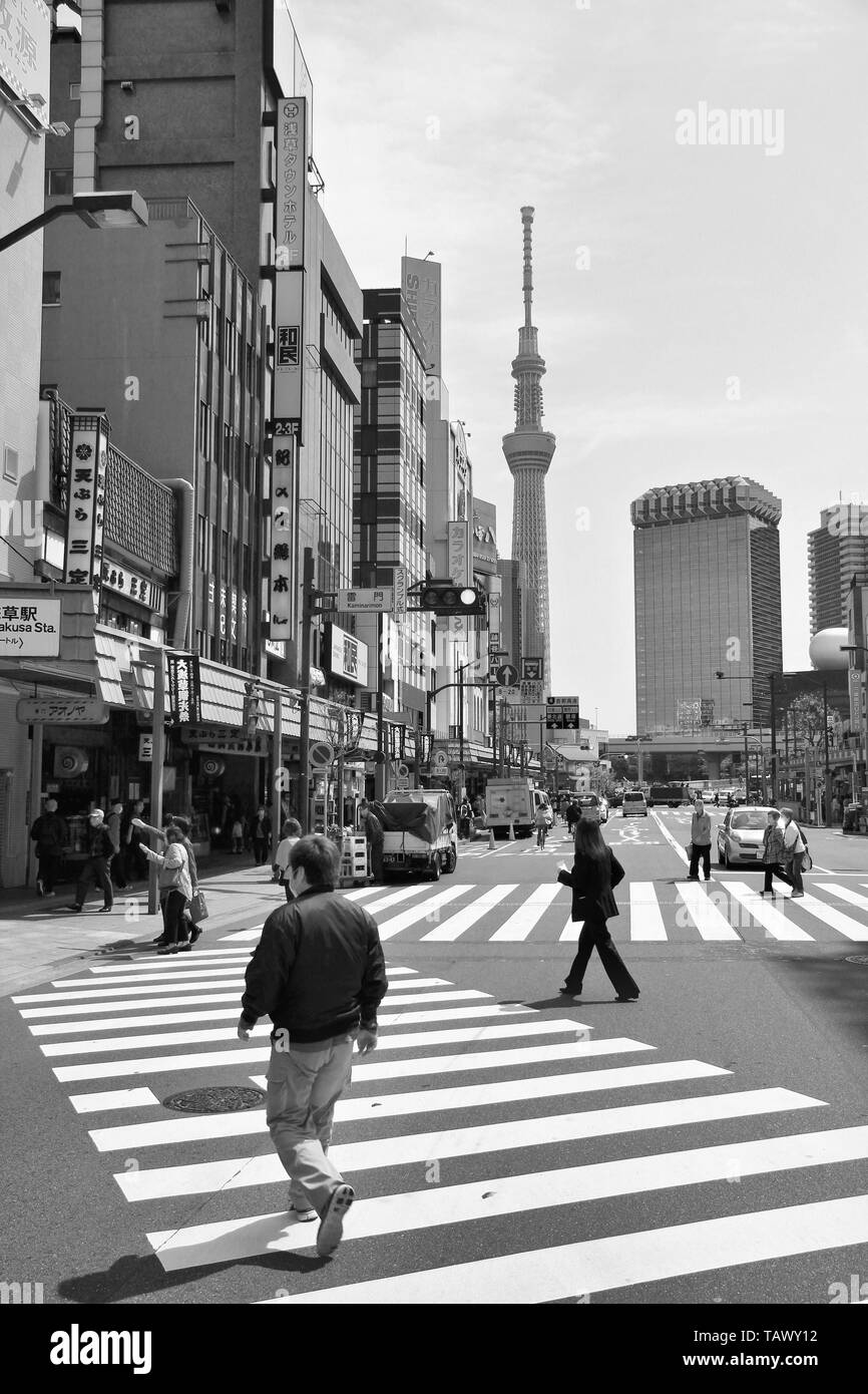 TOKYO, JAPAN - APRIL 13, 2012: Man crosses street in Asakusa district, Tokyo. Asakusa is one of the oldest districts of Tokyo, capital city and larges Stock Photo