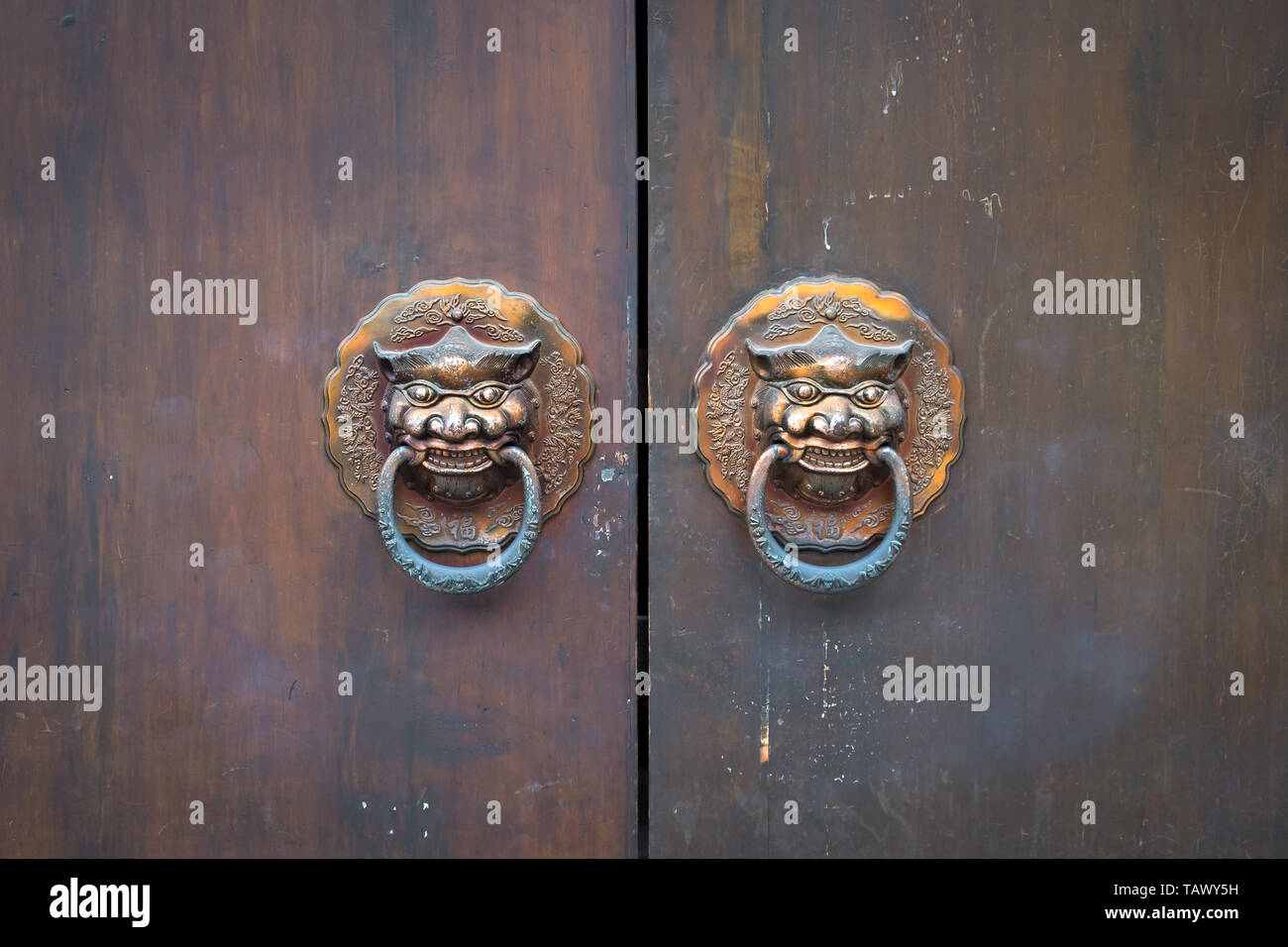 Wooden door detail with lion door knockers close up, Asia. Chinese style architecture of temple . Stock Photo