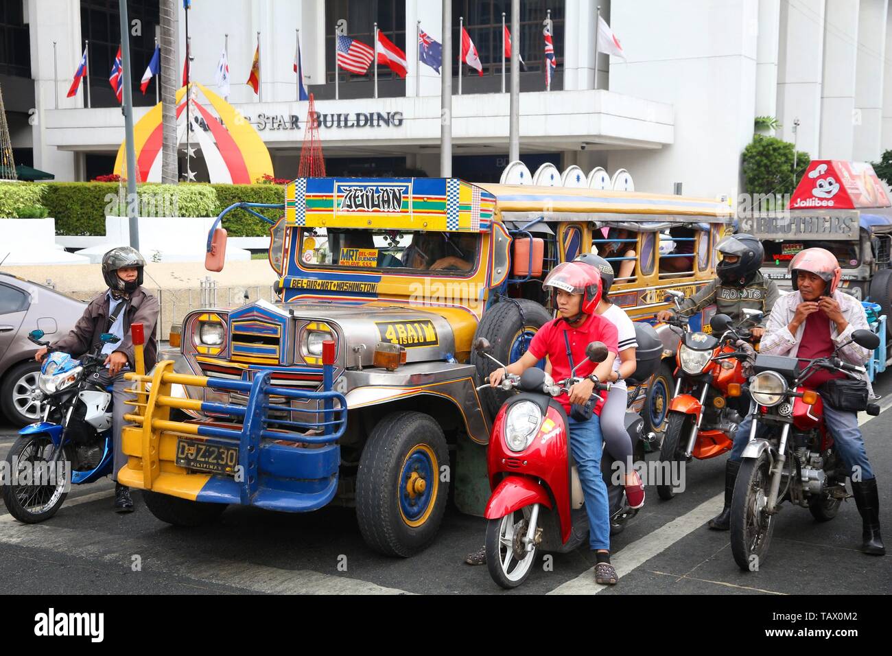 MANILA, PHILIPPINES - DECEMBER 7, 2017: People ride a jeepney public transportation in heavy traffic in Manila, Philippines. Metro Manila is one of th Stock Photo
