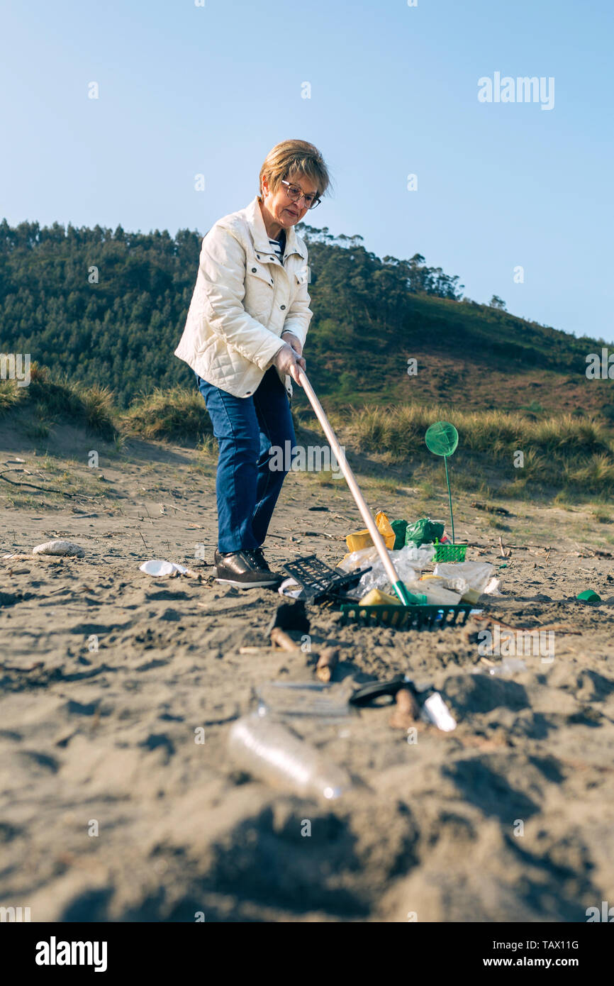 Female volunteer cleaning the beach Stock Photo