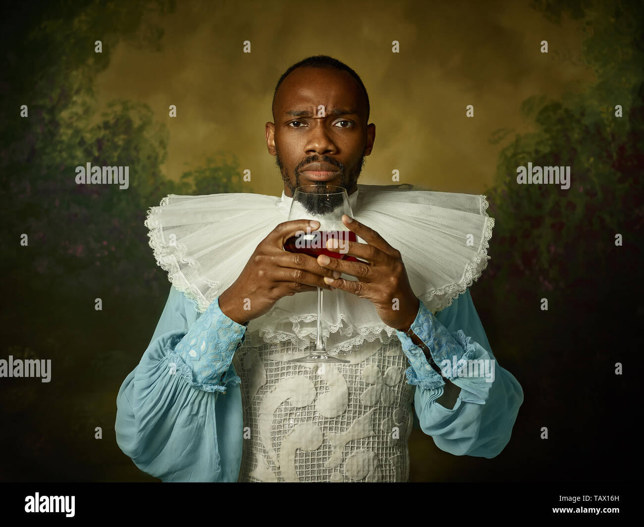 Grandee Young man as a medieval grandee or nobleman on dark studio background ...