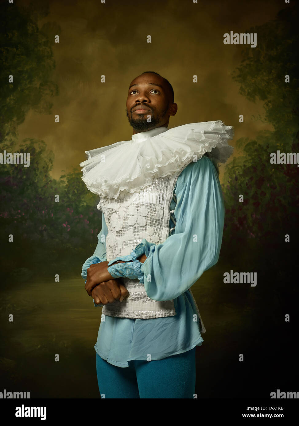 Grandee Young man as a medieval grandee or nobleman on dark studio background ...