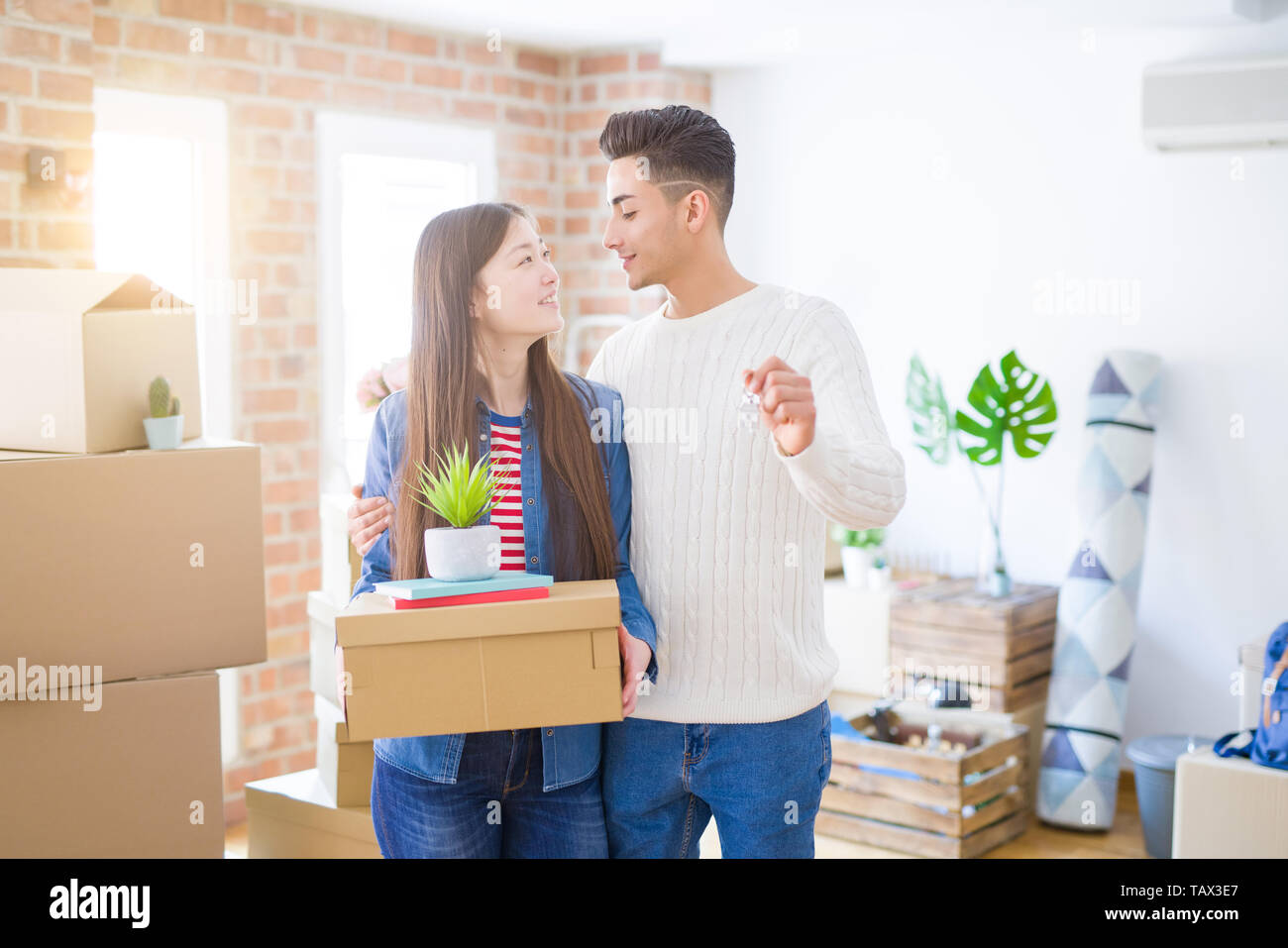 Young asian couple holding keys of new house, smiling happy and excited ...