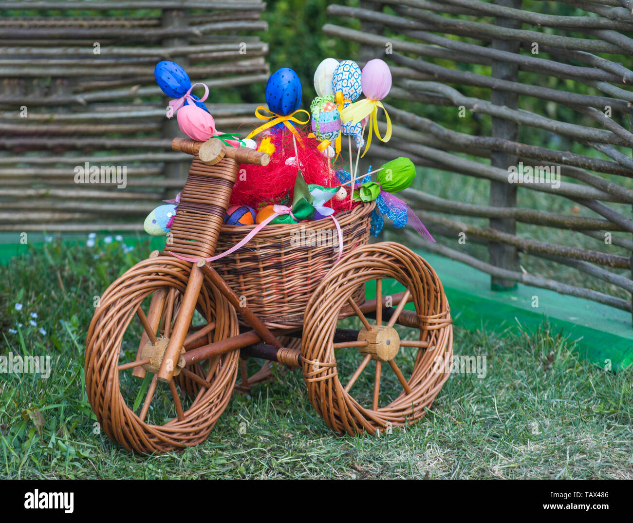 Happy easter celebration. Wicker tricycle with basket on grass