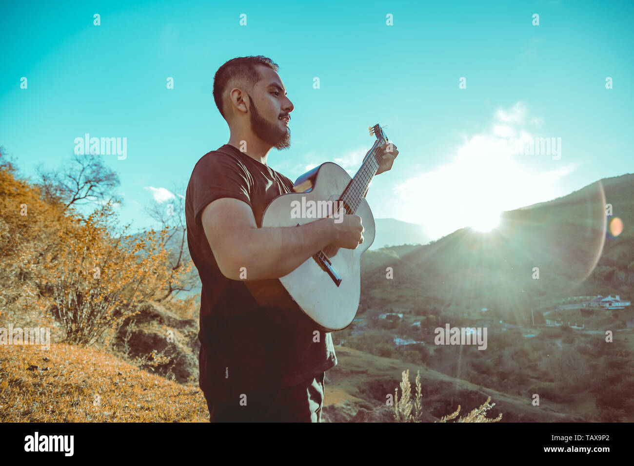 Man playing guitar on mountains Stock Photo