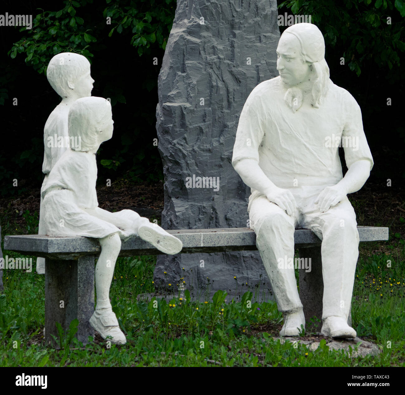 Statue of Nikolaus Ludwig, Reichsgraf von Zinzendorf und Pottendorf teaching children while sitting on a stone bench in a park. Stock Photo