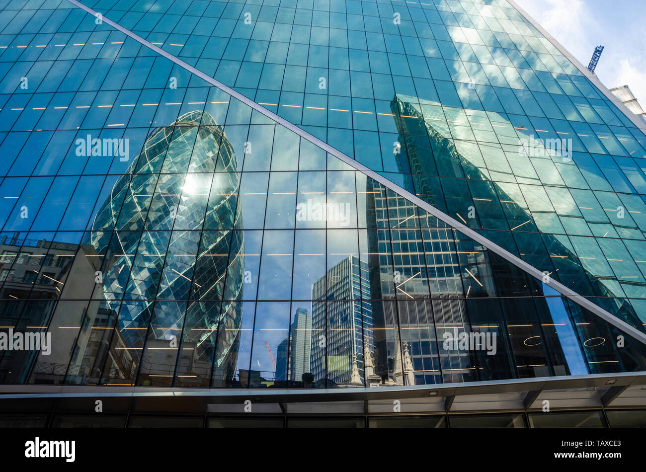 The Gherkin is seen in a reflection int he side of The Scalpel in The financial district in The City of London, UK Stock Photo