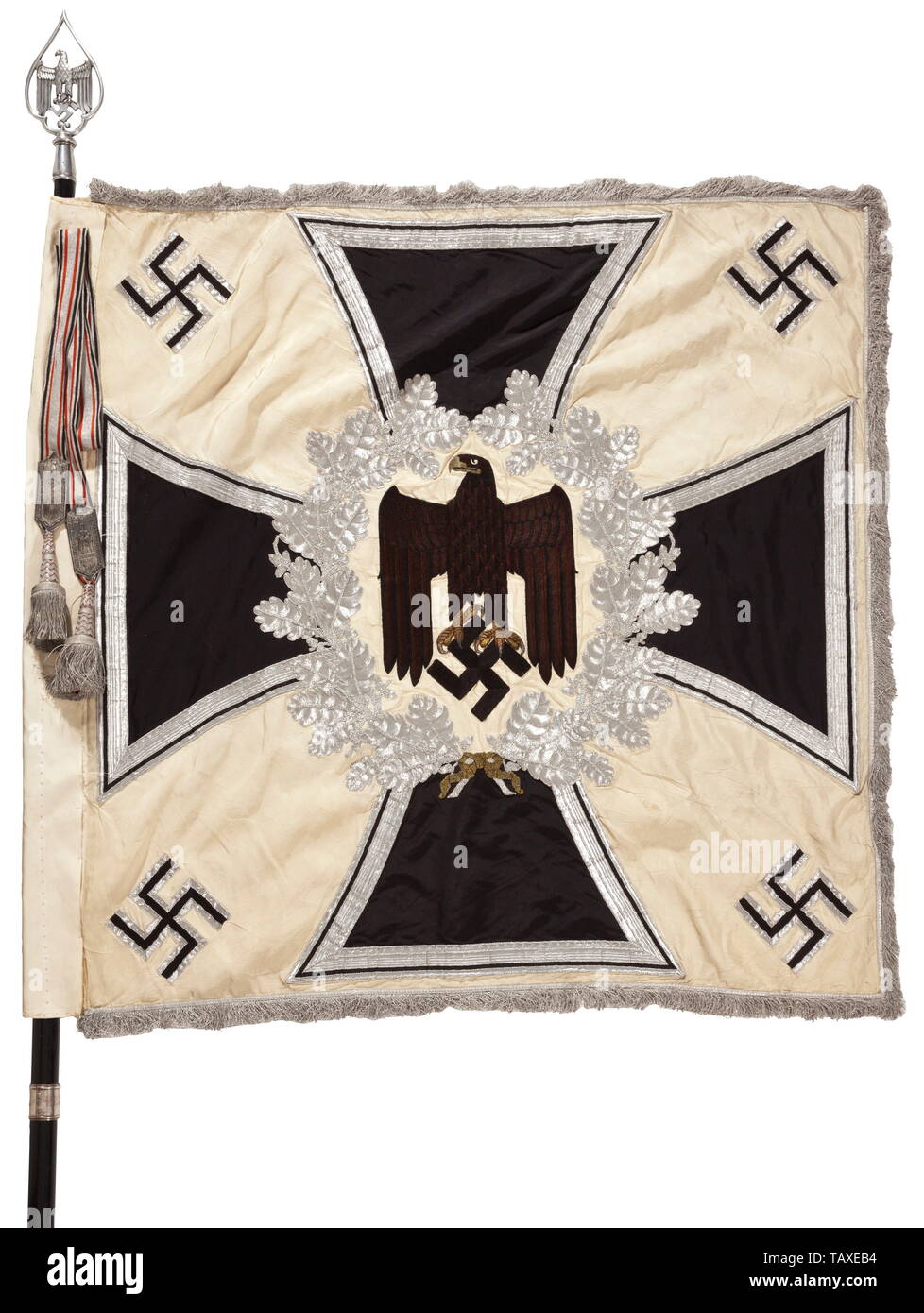 A battalion flag of III Battalion Infantry Regiment 52, complete with pole, finial and banderole, White silk cloth fringed with silver on three edges. On both sides a hand-embroidered black army eagle with brown plumage, the beak and talons in raised gold embroidery on a field of cream-coloured silk, surrounded by a silver embroidered wreath of oak leaves on an Iron Cross, in the corners four applied swastikas. Dimensions ca. 120 x 120 cm. The black polished wooden flagpole with engraved silvered battalion ring. The attachment nails (tarnished) w, Additional-Rights-Clearance-Info-Not-Available Stock Photo
