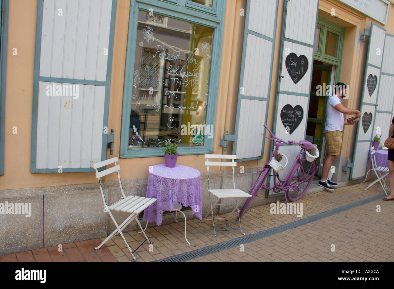 Small cute bar with table outside on sidewalk, with vintage bicycle as an decoration Stock Photo