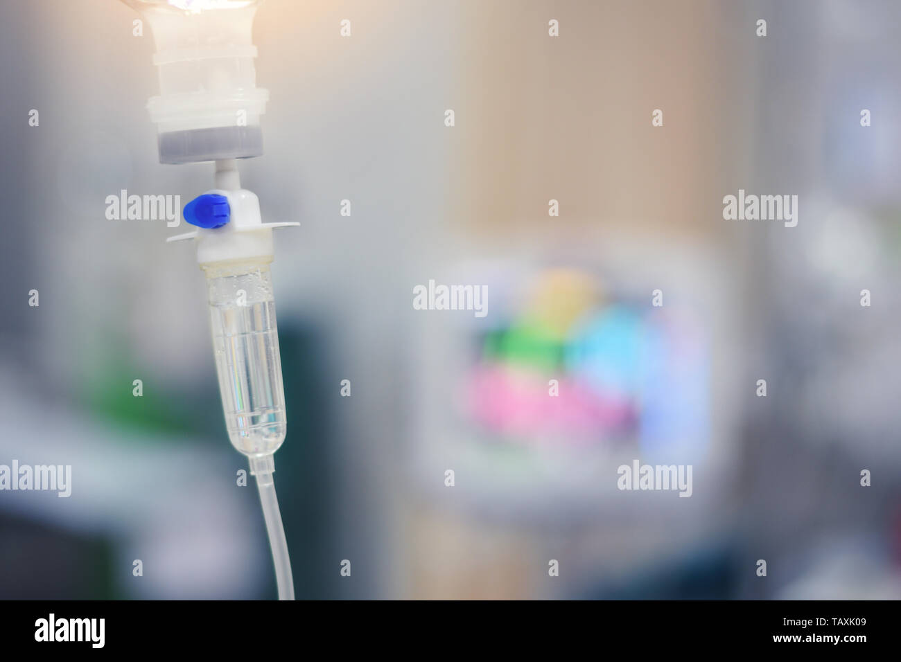 IV infusion set and bottle on a pole. Liquid saline is slowly dripping drops of drugs, medicine or antibiotic therapy and surgery recovery in a Stock Photo