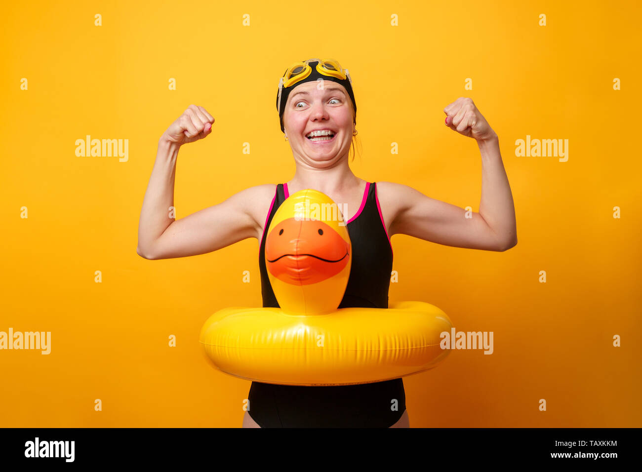 Image of strong woman in swimsuit with life preserver on empty orange