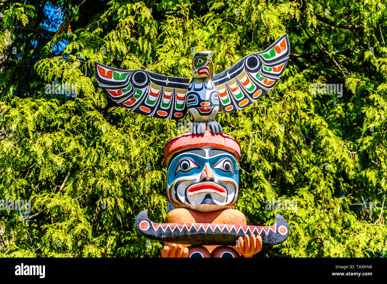 The colorful 'Ga'akstalas Totem Pole' depicting a Quolous, a legendary bird. One of the most colorful and intricately carved totem poles in Vancouver Stock Photo