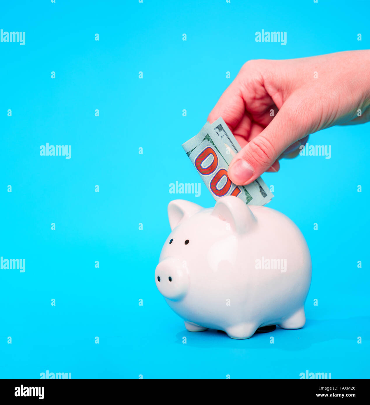 Picture of hand of man putting money into piggy bank Stock Photo - Alamy
