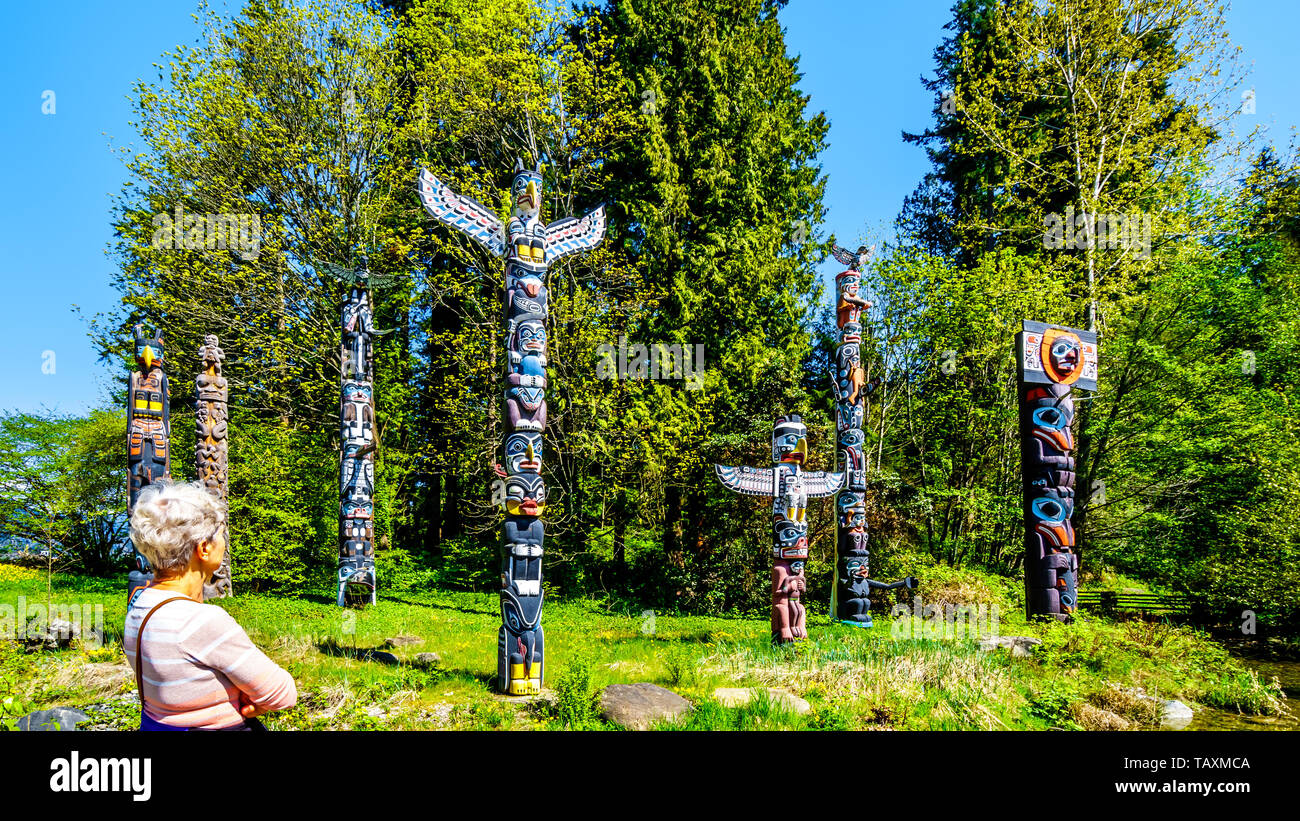 Colorful indigenous Totem Poles representing art and religious symbols of West Coast Indigenous peoples placed in Stanley Park in Vancouver BC, Canada Stock Photo