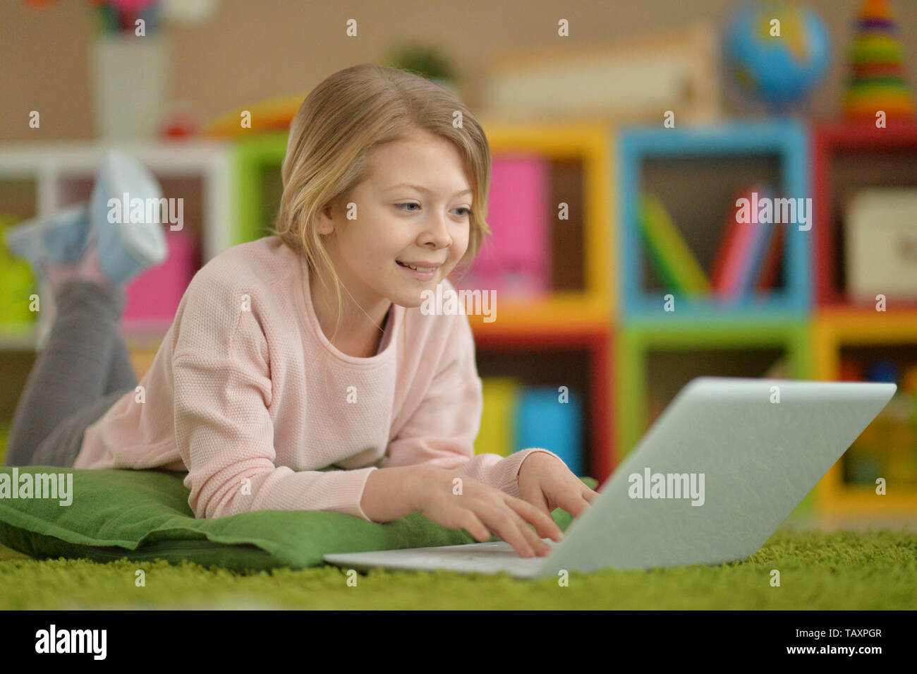 Portrait of girl using modern laptop while lying on floor Stock Photo ...