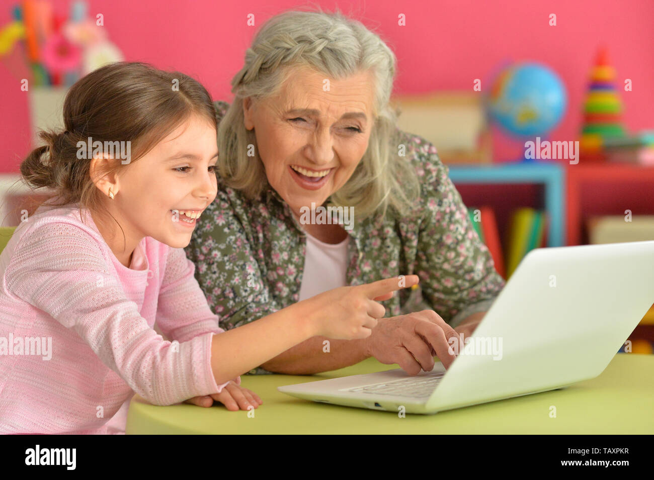 Portrait of girl with grandmother using laptop Stock Photo - Alamy