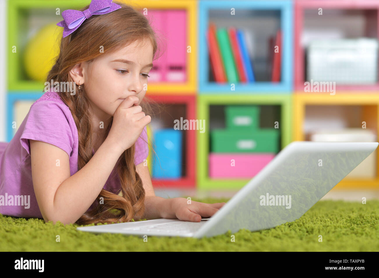 Portrait of girl using modern laptop while lying on floor Stock Photo ...