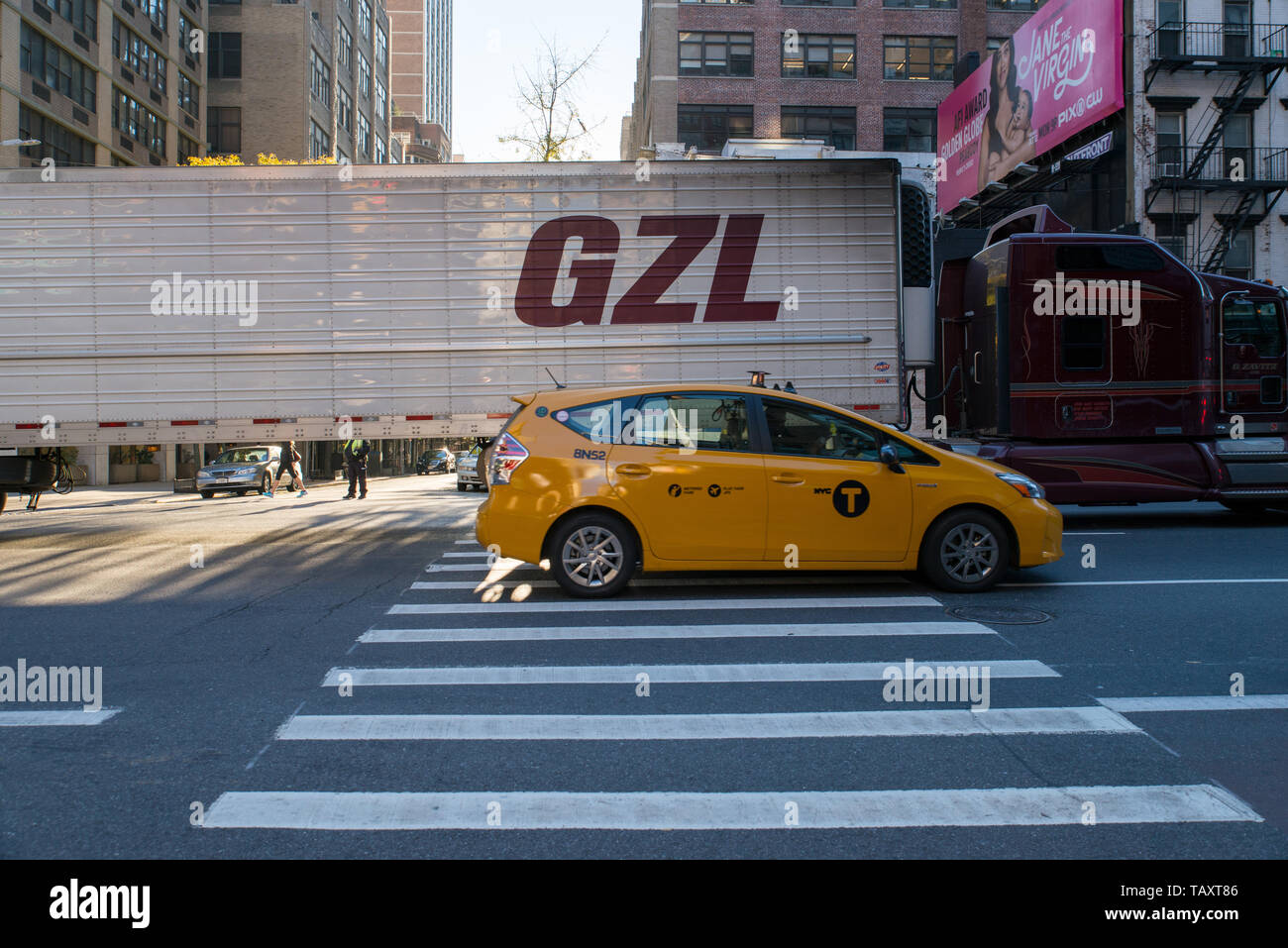 Fahren Sie mit einem Taxi, das einen LKW oder einen Lastwagen in Manhattan, NYC, USA führt./ Taxi passing a truck in Manhattan, NYC, USA. Stock Photo