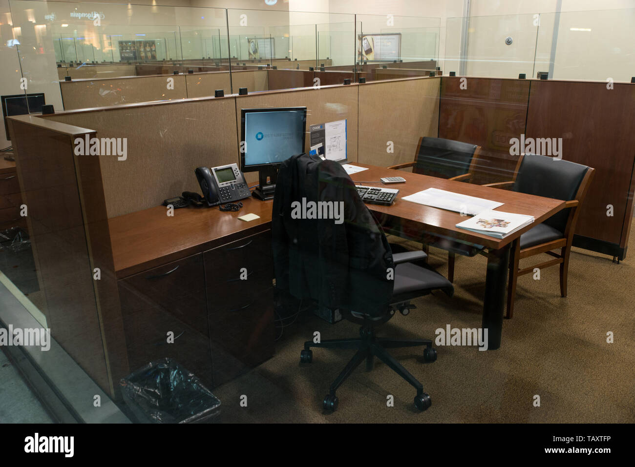 Jacket on the back of a chair in an empty office at night, Manhattan, New York, USA. Stock Photo