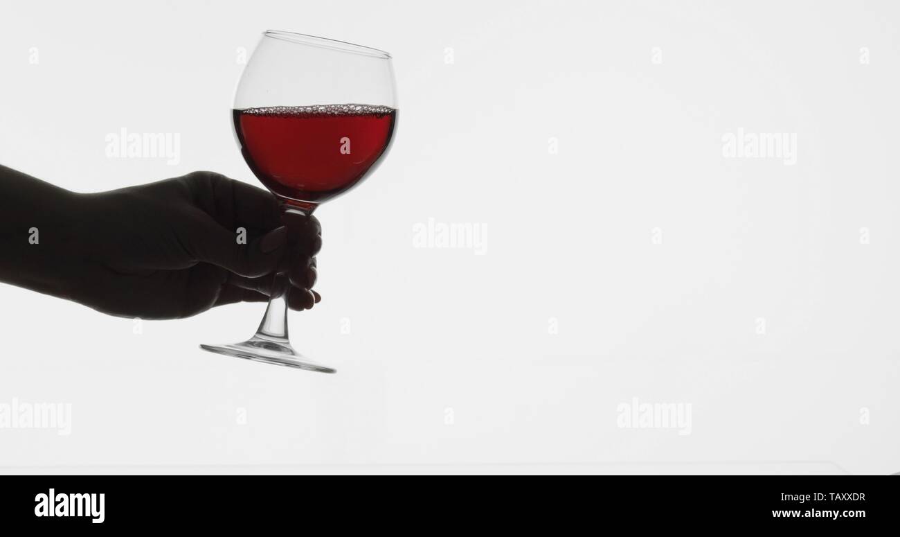 Rose wine. Woman hold red wine in wine glass over white background