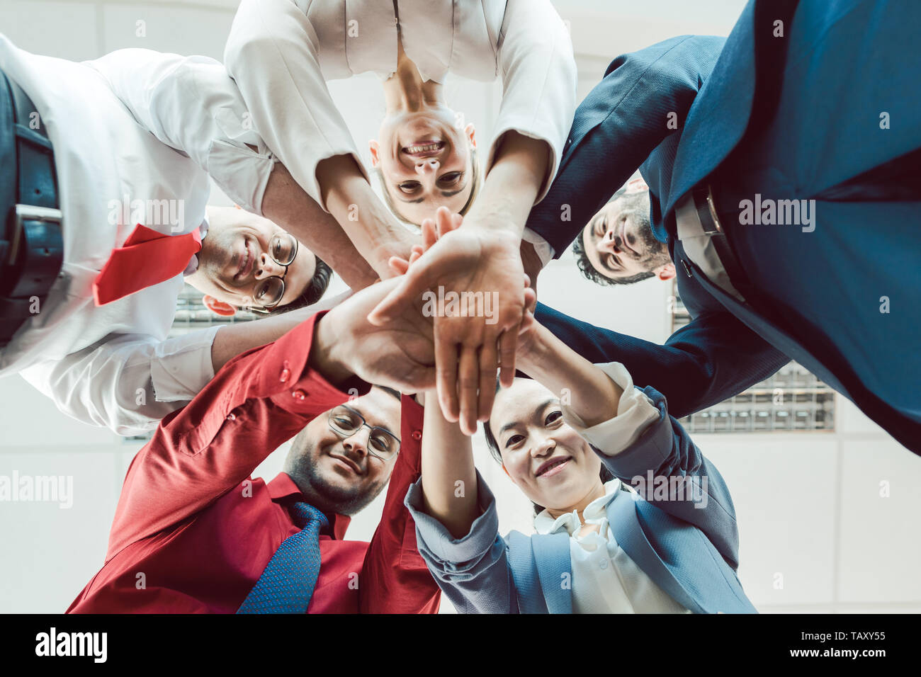 Team of diverse business people stacking their hands together Stock Photo