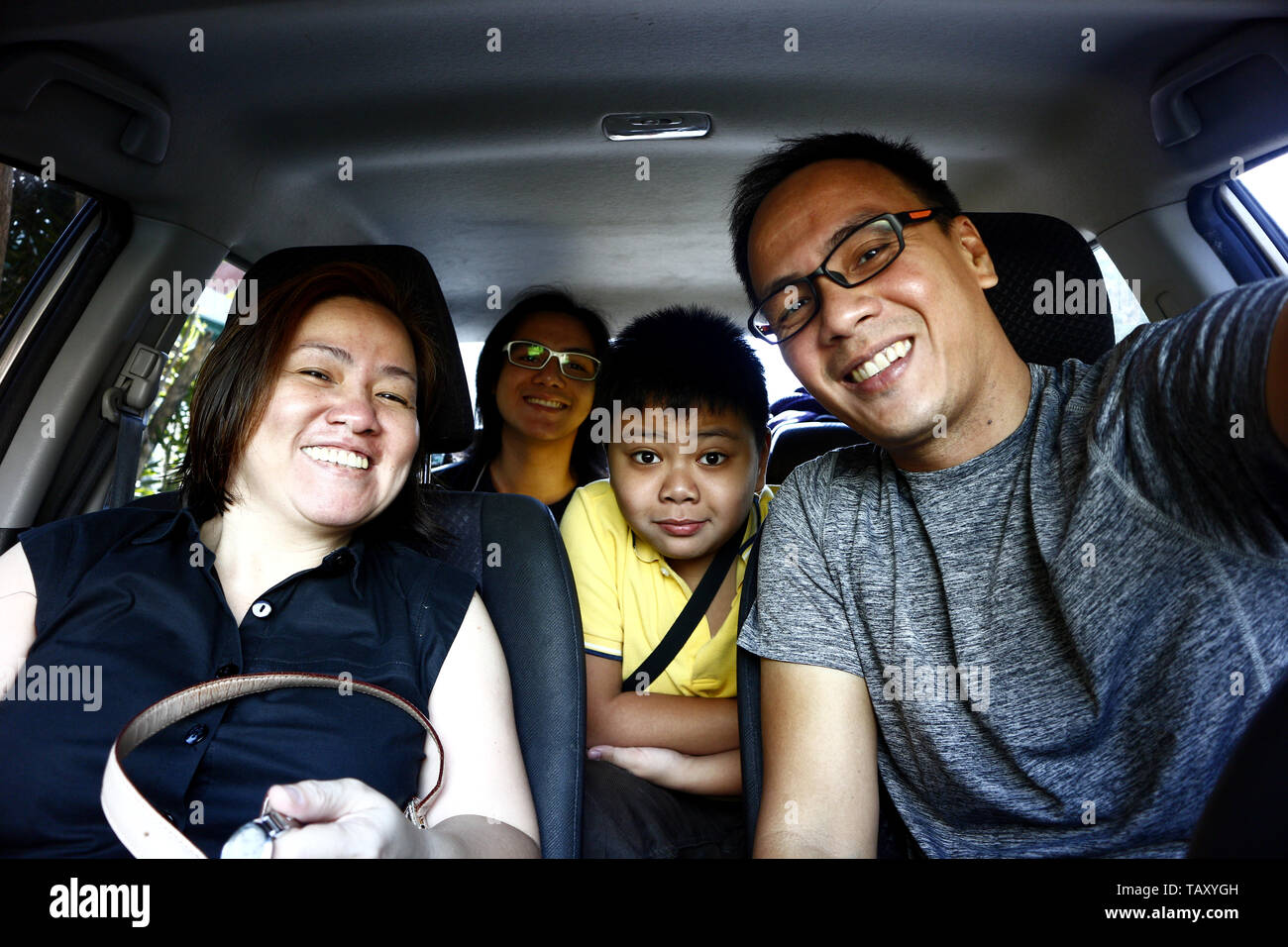 Portrait of a young Filipino family inside a car Stock Photo