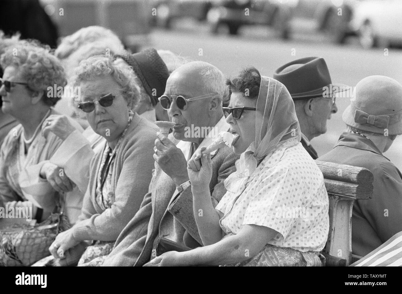 Holiday scenes at Brighton  Holidaymakers enjoying the hot weather by cooling off with an ice cream. 7th July 1963 Stock Photo