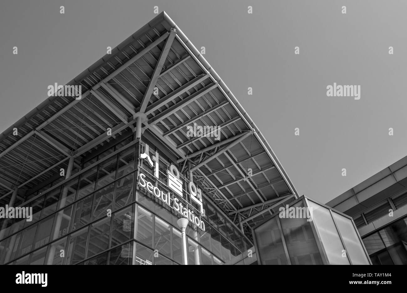 Seoul, South Korea - March 2018: exterior glass facade of the Station, a name also reported in the Korean alphabet, taken from below, black and white. Stock Photo