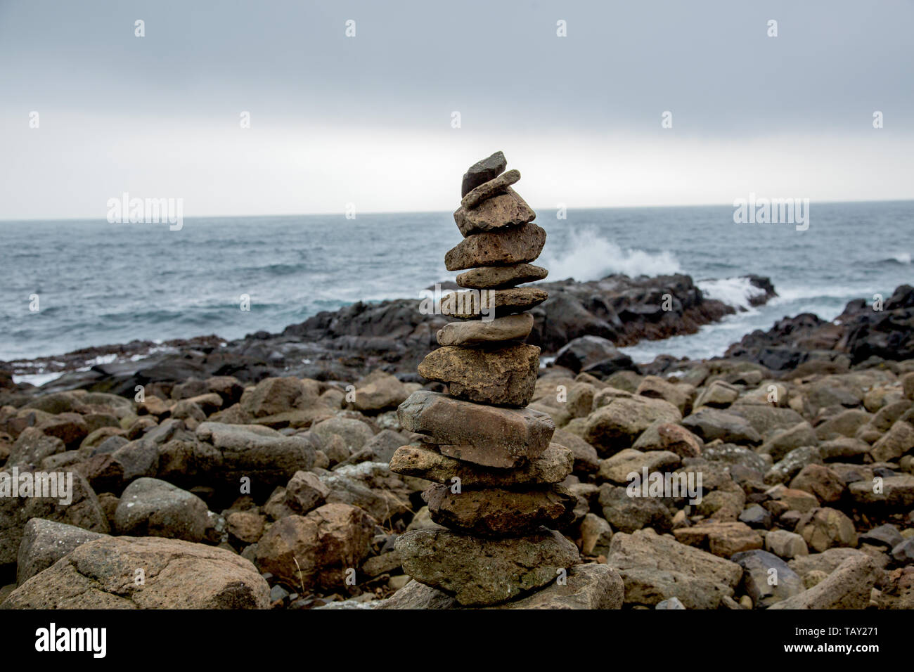 Cairn in front of coastal landscape at stormy weather in Iceland Stock Photo