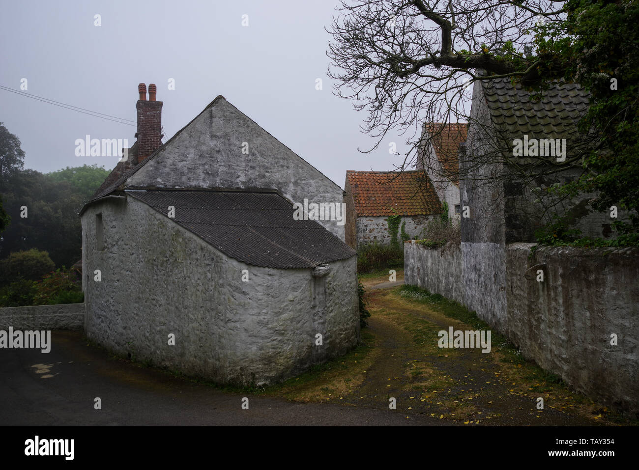 Sea fret surrounding quaint old farm houses on Guernsey - Channel Islands, UK Stock Photo