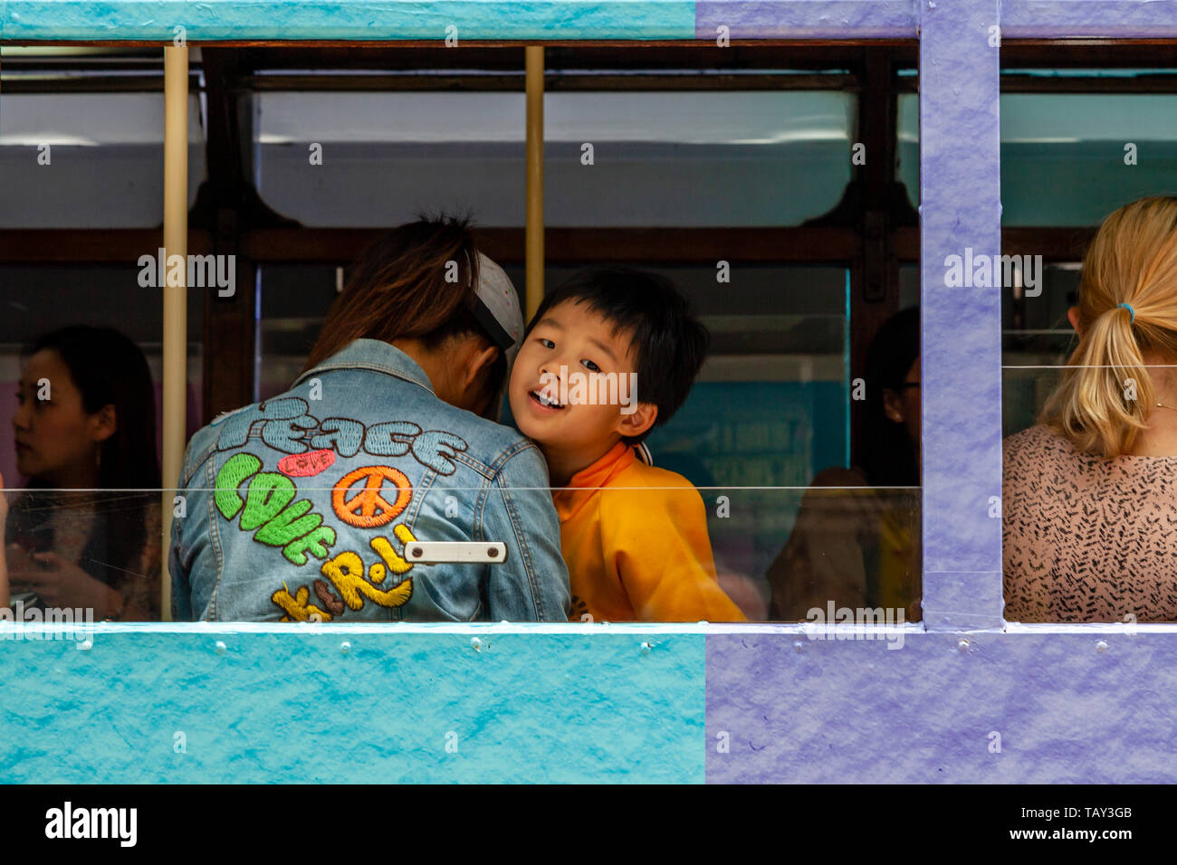 A Young Boy Looks Out The Window Of A Traditional Hong Kong Electric Tram, Hong Kong, China Stock Photo