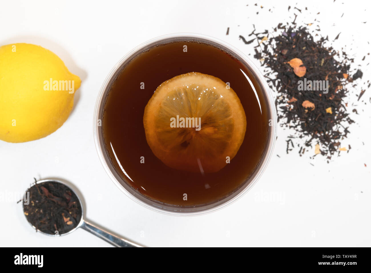 Lemon tea cup top view with lemon slice and fruit and tea leaves in background Stock Photo