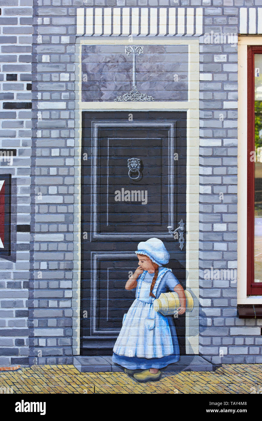 Close-up of a milk girl in traditional attire with wooden clogs on a beautiful graffiti/wall painting in Zierikzee (Zeeland), Netherlands Stock Photo