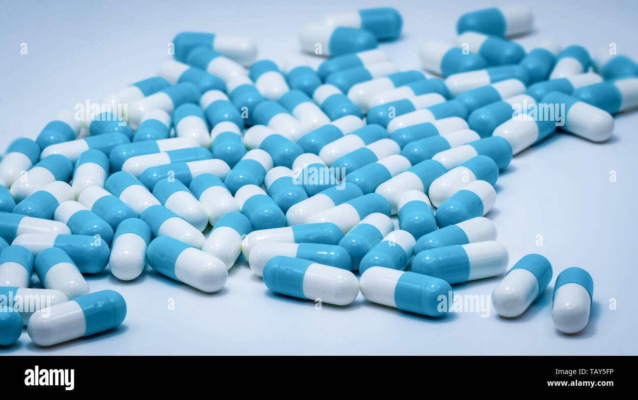 Blue and white capsule pills on white background. Antibiotics drug resistance. Antimicrobial capsule pills. Pharmaceutical industry. Healthcare and dr Stock Photo