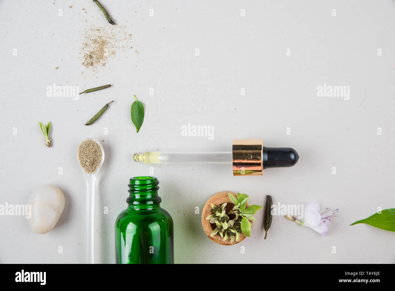 The minimal style. Natural cosmetics, handmade skin and body care. A green bottle with pipets and plants. The concept of orangic cosmetics. Flat lay Stock Photo