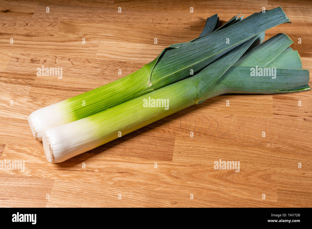 Freshly harvested leeks on a wooden table Stock Photo
