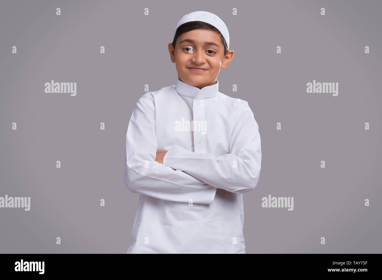 Young Muslim boy wearing cap with hands folded and smiling Stock Photo ...